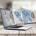 augmented reality marketing: an image of a laptop with two screens coming off it that has digital marketing icons and a woman pointing to them